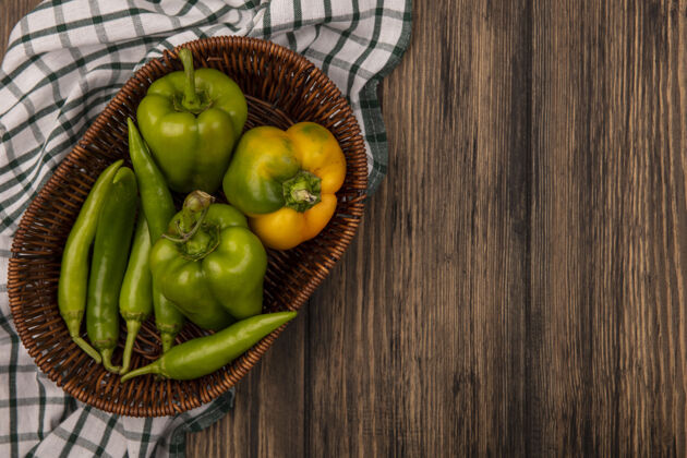 烹饪顶视图新鲜健康的辣椒桶上的格子布上的木墙与复制空间菜肴蔬菜膳食