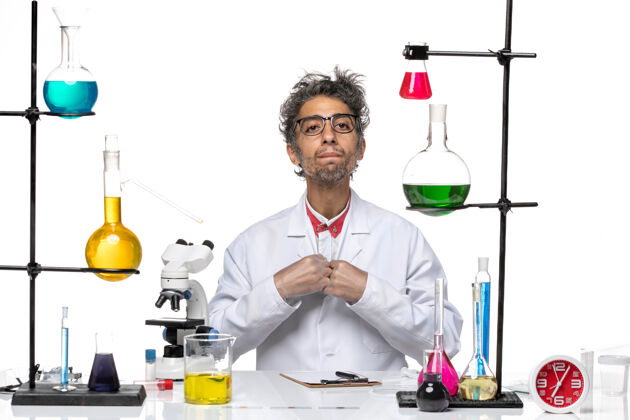 化学家正面图穿着白色医疗服的中年化学家拿着溶液坐着临床前面人