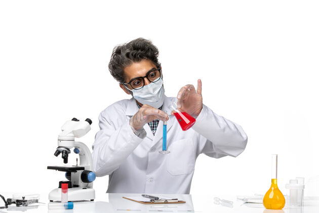 科学正面图穿着特殊套装的中年科学家坐着拿着装有混合溶液的烧瓶特殊男专业