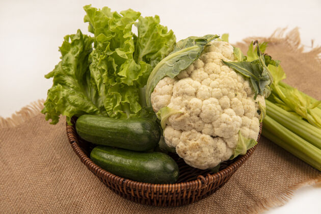 土豆健康蔬菜的俯视图 如莴苣 花椰菜和黄瓜 放在一个袋子布上 芹菜被隔离在白色的墙上黄瓜蔬菜桶
