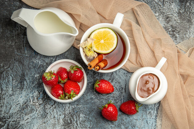 食物顶视图新鲜草莓与一杯茶在黑暗的浅红色水果浆果表面早餐盘子甜点