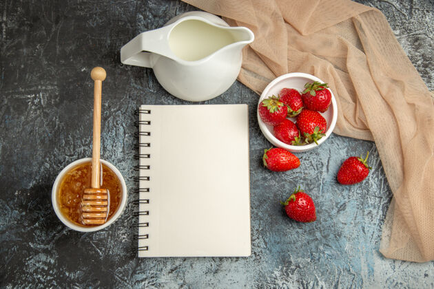 盘子顶视图新鲜的红色草莓与蜂蜜在黑暗的浅红色水果浆果表面勺子早餐碗