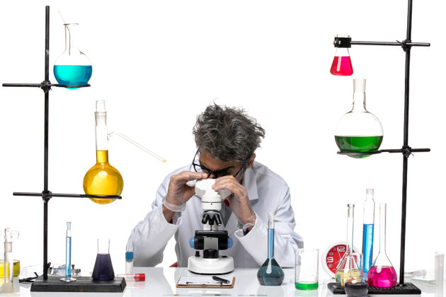 化学穿着白色医疗服的男性科学家使用显微镜的前视图人人医学