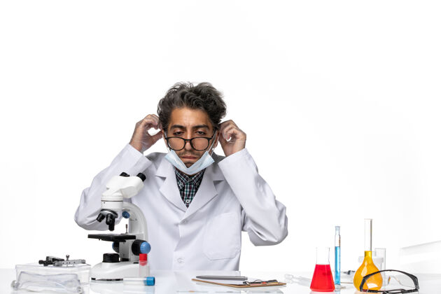 化学正面图身着特殊套装的中年科学家围坐在桌子旁 拿着显微镜和溶液人科学化学