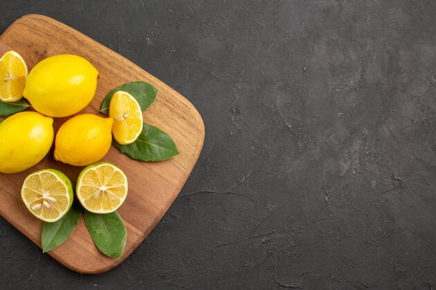 柑橘在深灰色的桌子上俯瞰新鲜柠檬酸水果柑橘酸橙水果顶部健康新鲜柠檬
