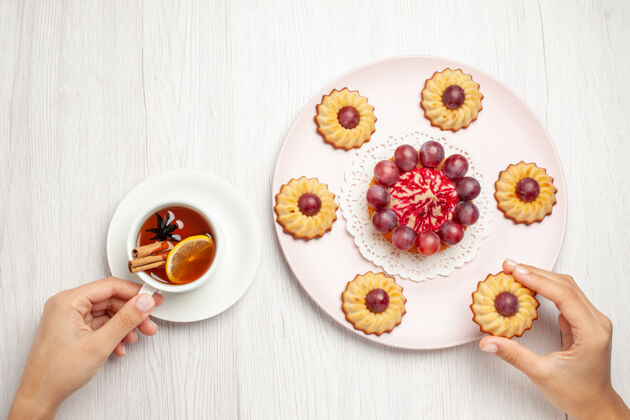 派俯瞰美味的葡萄饼干和一杯茶放在白色的桌子上甜甜的饼干派早餐食物盘子