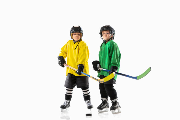 活跃冰球场上的小冰球手 背景是白色的游戏冰设备