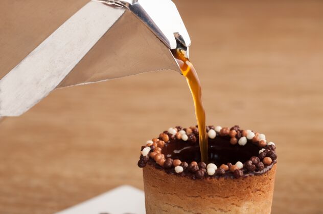 食物选择性聚焦拍摄咖啡倒在饼干杯在木制表面零食松饼纸杯蛋糕