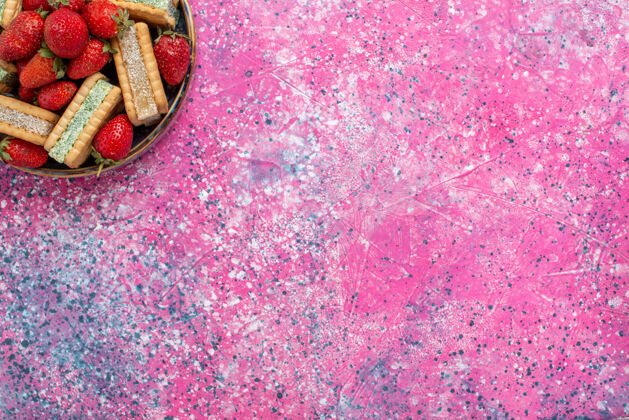 质地美味的华夫饼干的顶视图 粉色表面有新鲜的红色草莓华夫饼新鲜美味