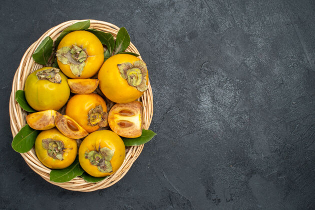 顶部顶视图新鲜甜甜的柿子在篮子里放在深色的桌子上 水果成熟的味道秋季黄色深色