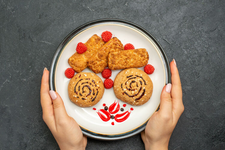 美味顶视图美味甜饼在盘子里灰色背景饼干甜糖蛋糕饼干茶盘子饼干晚餐