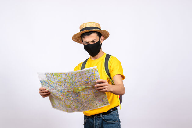 工作前视图焦躁不安的年轻人穿着黄色t恤和面具看着地图激动的年轻人地图成人