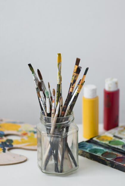 艺术家道具桌上的艺术家道具收藏罐子绘画画笔