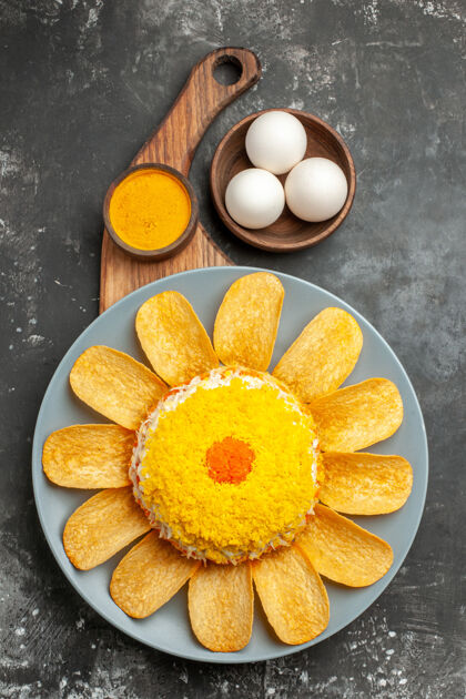 碗沙拉的顶视图在中间 盘子架在下面 药草和一碗鸡蛋放在深灰色的桌子上鸡蛋健康香草