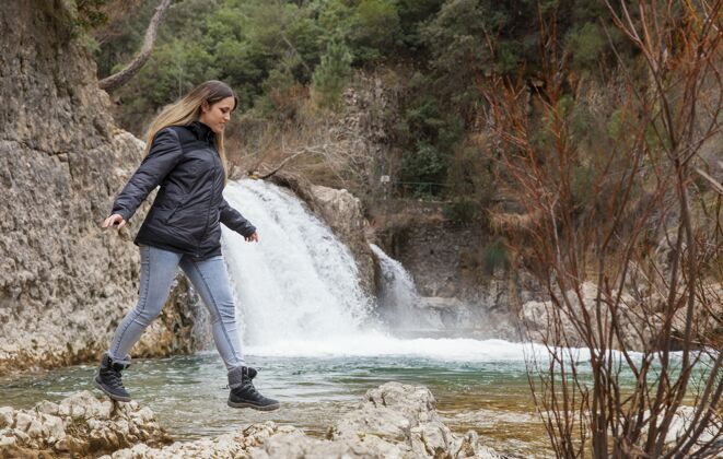 年轻享受大自然时光的女人探索瀑布冒险