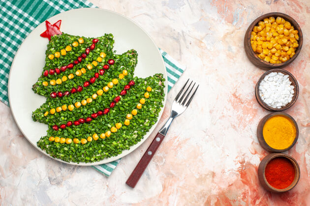 形状顶视图美味的绿色沙拉在新年树形状与调味品在轻背景光新的餐