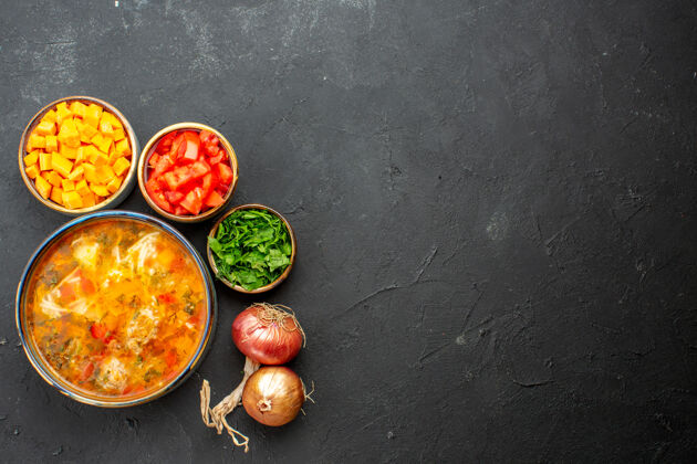 美味顶视图美味的肉汤与新鲜切片胡椒和绿色的灰色背景沙拉汤餐晚餐生的饮食观点