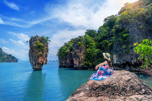 女人美丽的女孩坐在岩石上 在詹姆斯邦德岛在庞雅 泰国地标石头女性