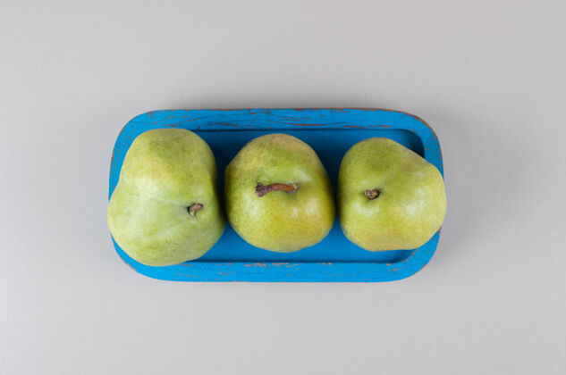 有机在大理石上放一把梨的蓝色盘子饮食健康水果