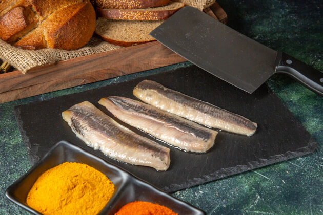 面包新鲜的生切碎的黑色木制切肉板香料面包切割器鱼顶视图切肉刀食物利器