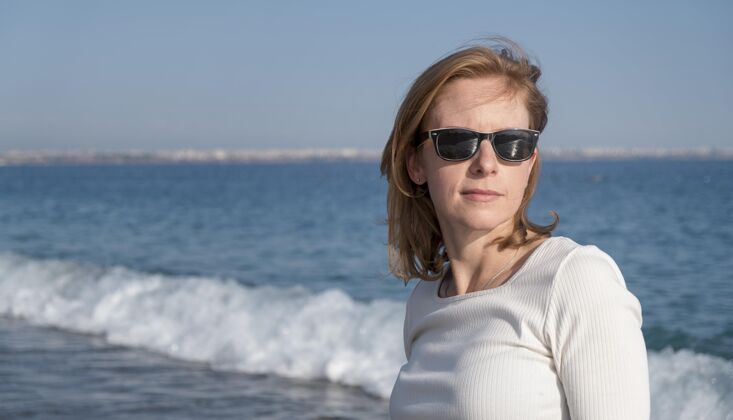 水平戴墨镜的中镜头女人女人度假海滨