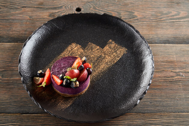 碎片紫色芝士蛋糕和浆果在盘子里新鲜美味芝士蛋糕