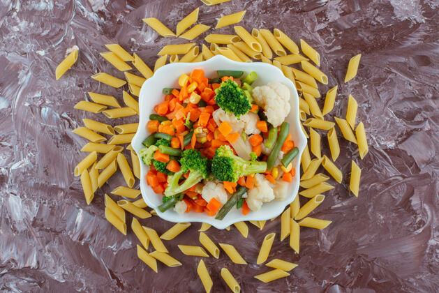 剁碎一碗白色的新鲜蔬菜沙拉和生鸡蛋放在大理石表面蔬菜干的健康