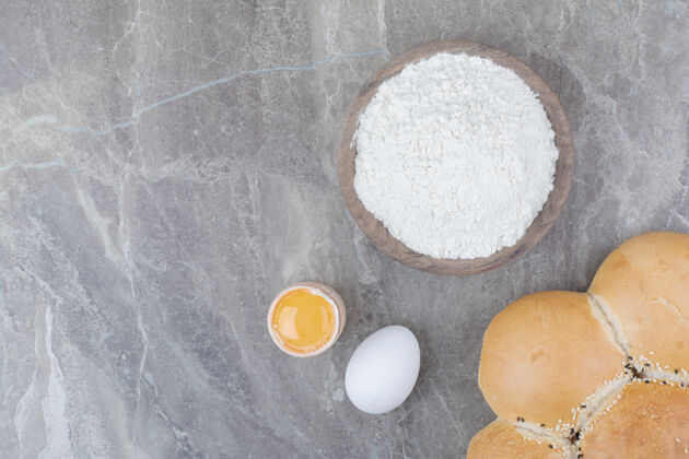 面包在木板上放一块蛋黄和面粉的白面包美味的鸡蛋糕点