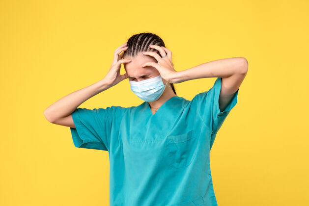 人正面图：穿着医用衬衫 戴着头痛面罩的女医生 大流行医院的健康护士covid-19医护人员头痛流行病女人