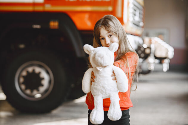 紧急情况消防站的孩子拿着玩具的女孩消防车附近的孩子救援汽车帮助