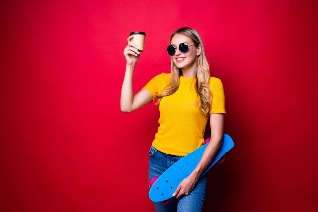 时尚肩上扛着滑板 咖啡靠着红墙的年轻女子女性生动运动
