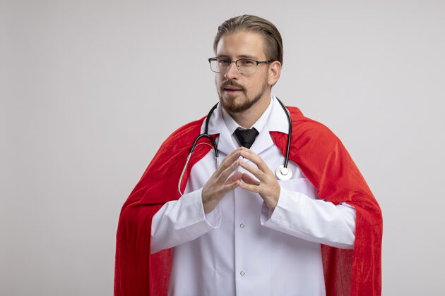 超级英雄一个可疑的年轻超级英雄 穿着医用长袍 戴着听诊器和眼镜 手牵着手 孤立地站在白色背景上医疗拿着一起