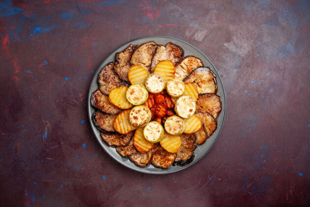 顶部顶视图烤蔬菜土豆和茄子在一个黑暗的空间盘子里烹饪腰果茄子