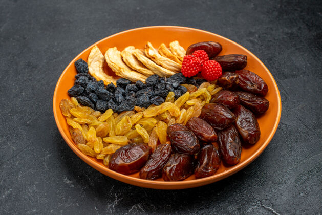 盘子前视图干果与葡萄干内板上的灰色空间美食早餐健康