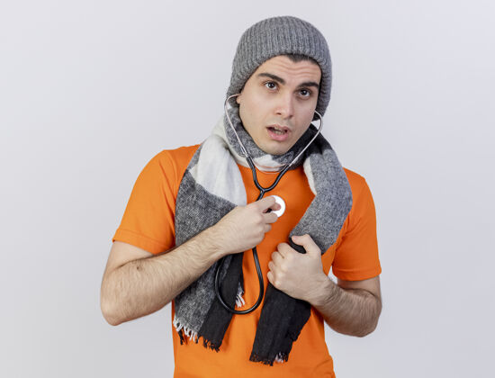 自己想着戴着冬天帽子戴着围巾的年轻病人 用听诊器在白色背景上听自己的心跳心跳围巾疾病