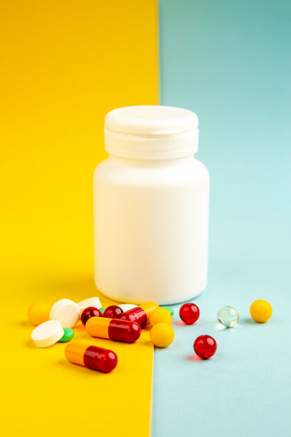 处方药前视图不同的药丸用塑料瓶放在黄蓝色的背景上卫生实验室科学医院冠状病毒-大流行的彩色药物病毒药品药瓶瓶子