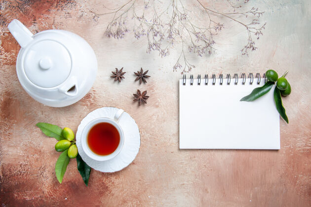 热的顶部特写查看一杯茶一杯茶白色茶壶柑橘水果八角笔记本笔记本茶碟咖啡