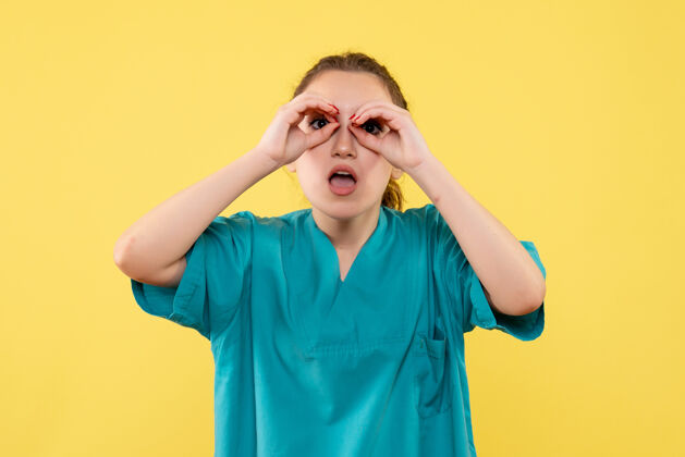脸黄墙上年轻女医生穿着医用衬衫的正面图快乐健康护士