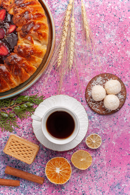 蛋糕俯瞰美味的草莓馅饼和浅粉色的茶杯肉桂饼干茶