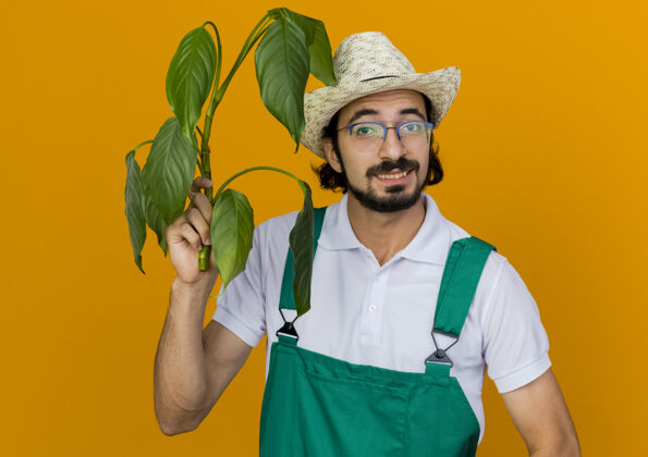 眼镜微笑的男园丁戴着眼镜戴着园艺帽捧着植物复制空间微笑