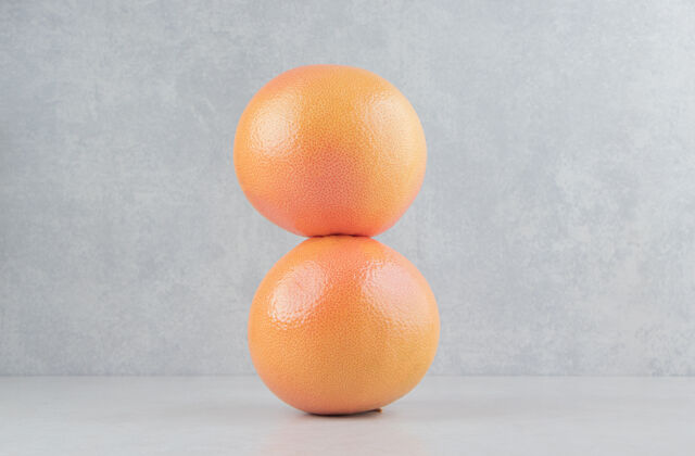 酸两个新鲜的橙子放在石桌上有机多汁柑橘