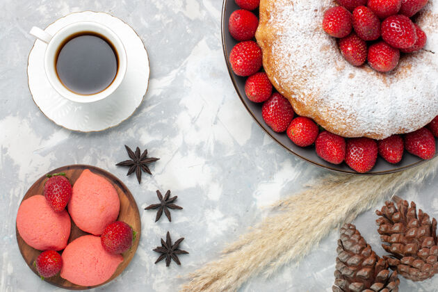 盘子顶视图美味的草莓派和一杯茶在灯光地板上杯子咖啡蛋糕