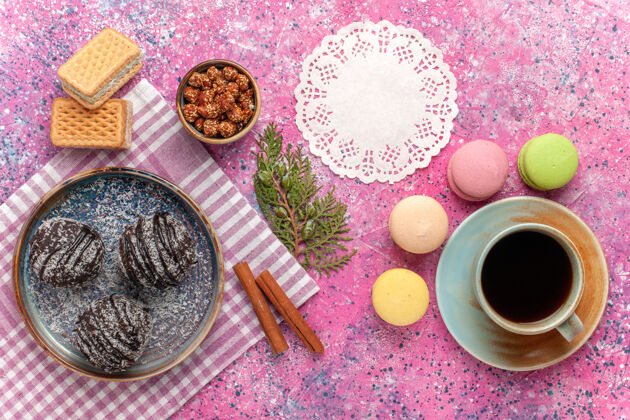 食物俯瞰美味的巧克力蛋糕 配上一杯茶和粉红色的麦卡龙杯子蛋糕水果