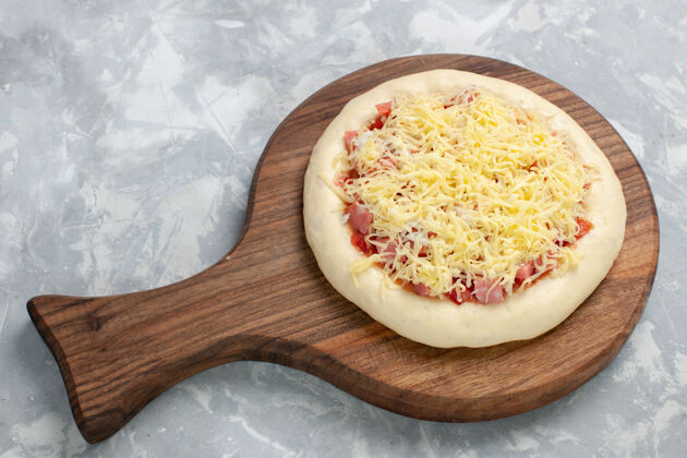 美味顶视图生披萨番茄酱和奶酪在一个白色的配料小吃饮食