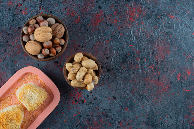 坚果一块粉红色的木板 背景是土耳其美食和健康的坚果核桃喜悦美味