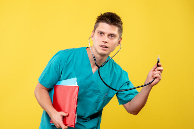 医院黄色墙上的男医生穿着医疗服 带分析和听诊器情绪分析健康
