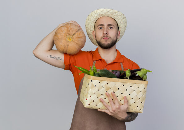 篮子自信的男园丁戴着园艺帽 手里拿着南瓜和菜篮空间穿南瓜