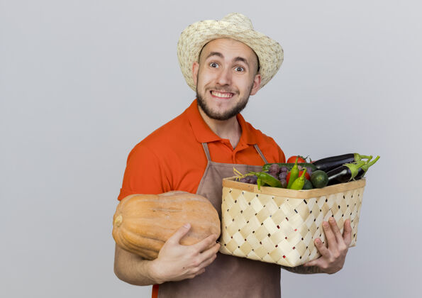 帽子兴奋的男园丁戴着园艺帽捧着南瓜和菜篮看花园蔬菜男