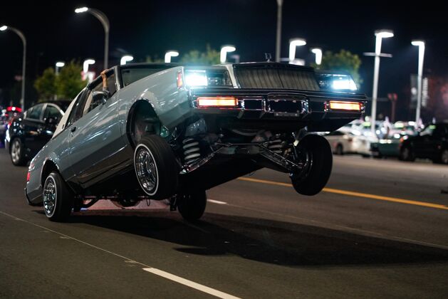 运动特写镜头的复古汽车只有后轮在地面上的街道在夜间铬汽车优雅