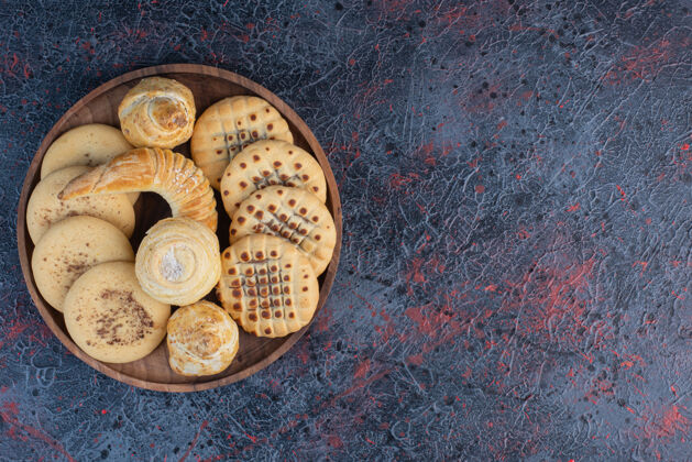 品种一堆饼干放在抽象桌上的小托盘上小吃可口美味